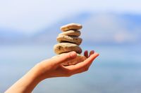 Steine in Hand; Steine sind Element Erde, Baguabereiche: Wissen/Weisheit, Beziehung/Patrnerschaft, Tai Chi, Glück und Zufriedenheit in Beziehung