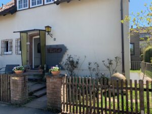Schön gestalteter Eingangsbereich eines Hauses mit Zwillingsobjekten, Brunnen, geschwungenem Weg.